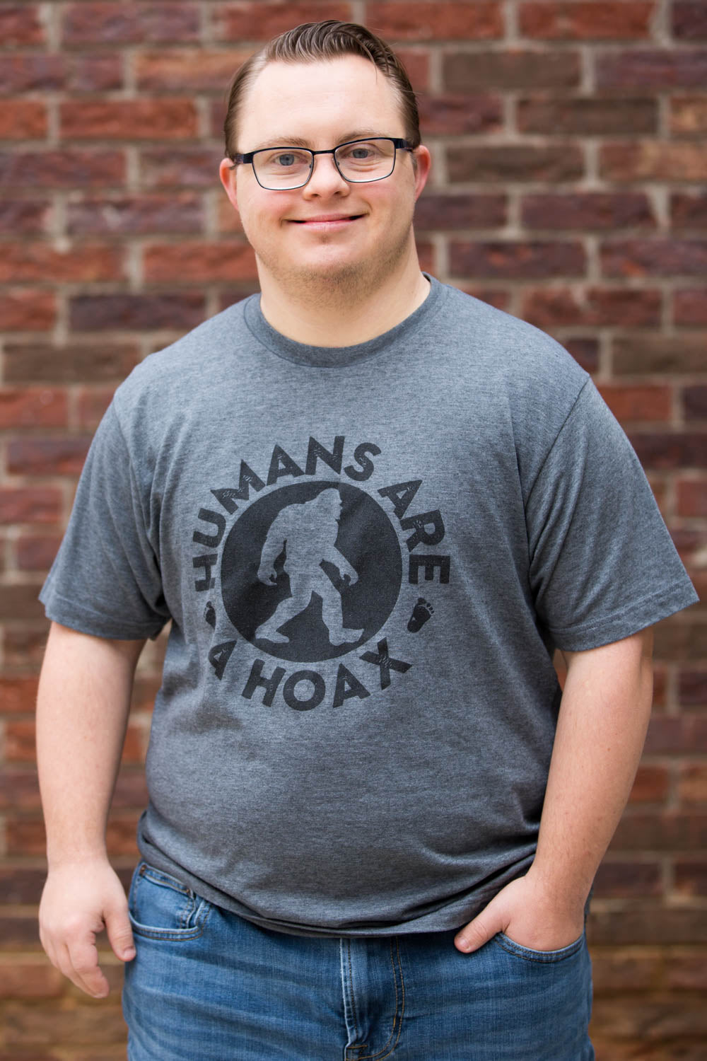 Man wearing a grey shirt with black bigfoot humans are a hoax imprint.