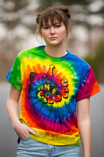 Woman wearing a tie dye shirt with white alien I come in peace imprint.
